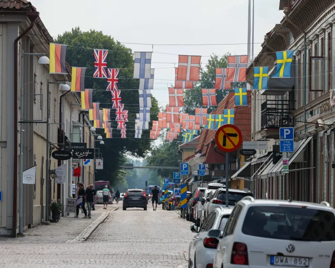 En gata med bilar parkerade på båda sidor om den.