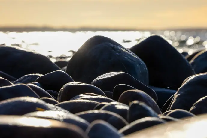 Stenar vid vatten med horisont i bakgrunden. 